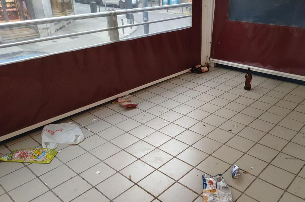 Restos de botellas y suciedad que debe retirarse cada mañana en el exterior del mercado. | DI