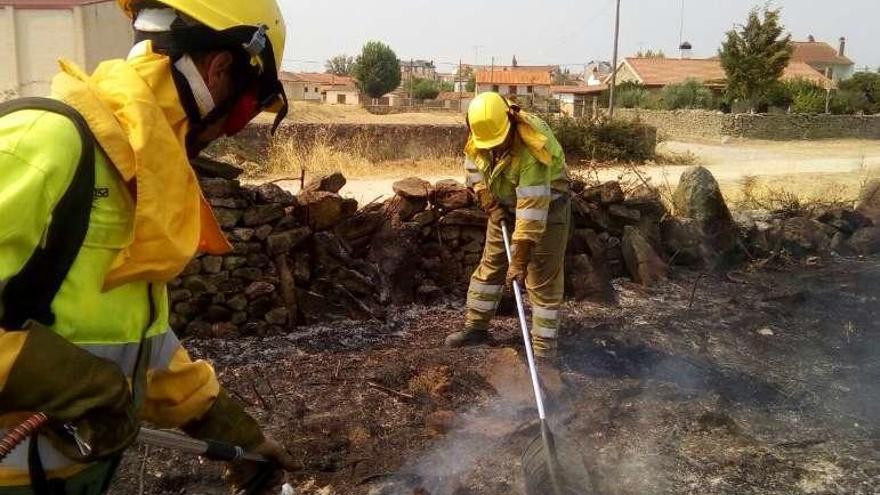 Dos trabajadores de un retén apagan el fuego de Muga.