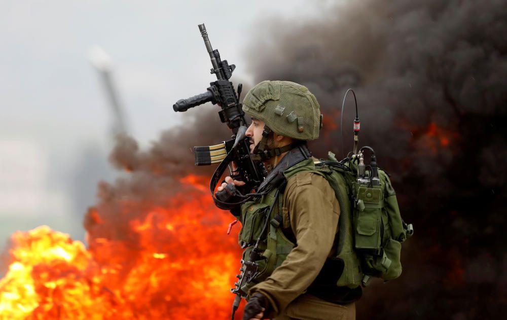 An Israeli soldier takes up position during ...