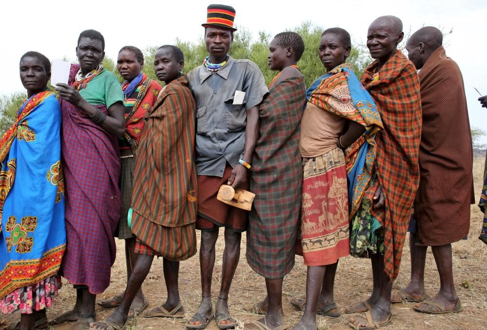 People from Karamojong tribe wait in line to ...