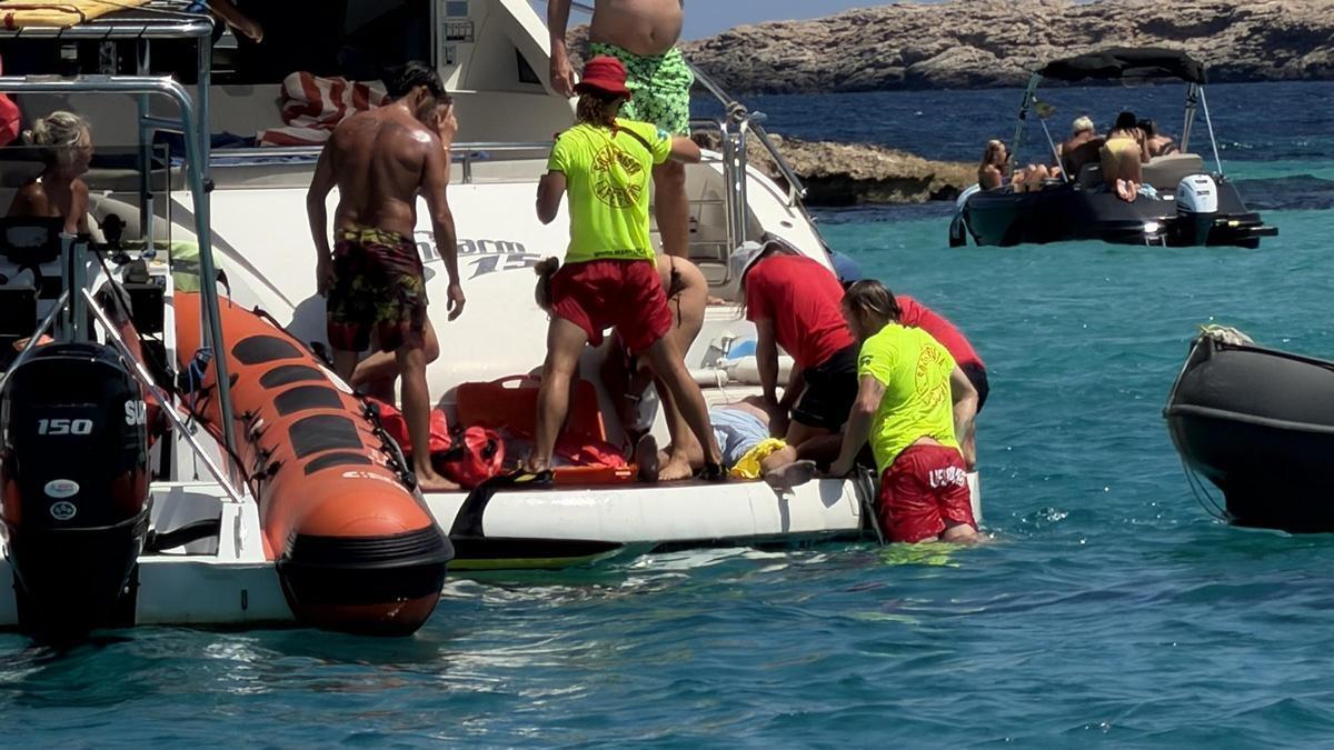 Los socoristas atienden al hombre en la popa del barco.
