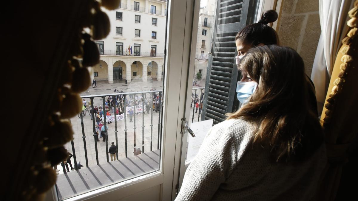 Julia Llopis observando a los manifestantes desde una ventana del Consistorio