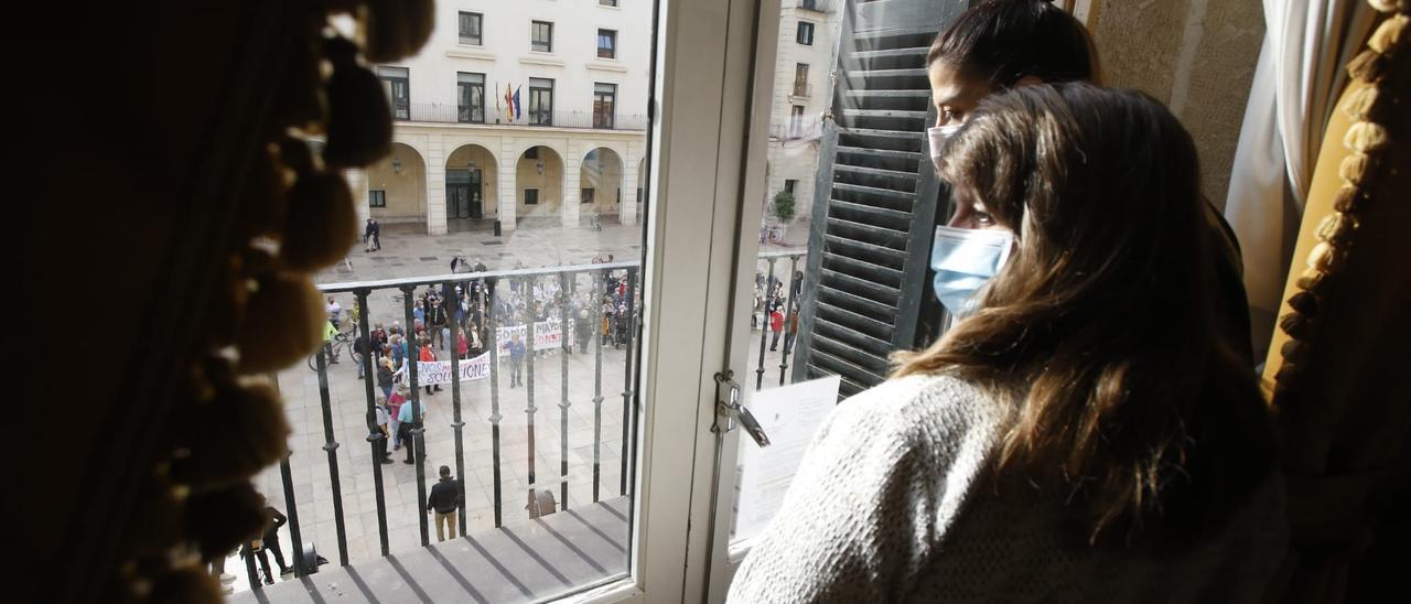 Julia Llopis observando a los manifestantes desde una ventana del Consistorio