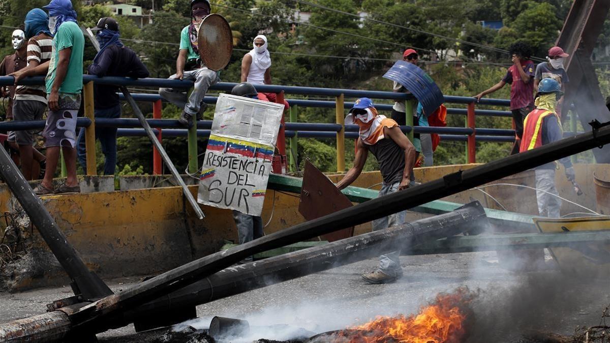 Manifestantes obstruyen una vía con una barricada en llamas, en Barquisimeto (Venezuela), el 26 de julio.