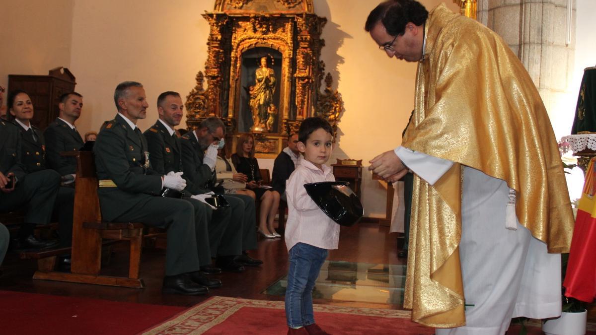 Un niño ofrece un tricornio en la misa en honor a la Virgen del Pilar en Puebla de Sanabria