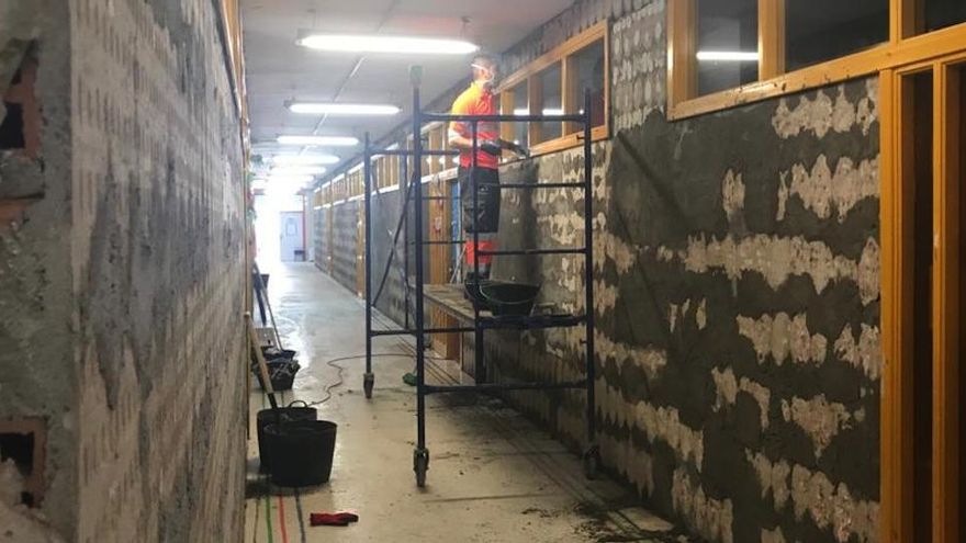 Un operario realiza obras de mejora en un tabique de un colegio de San Pedro.
