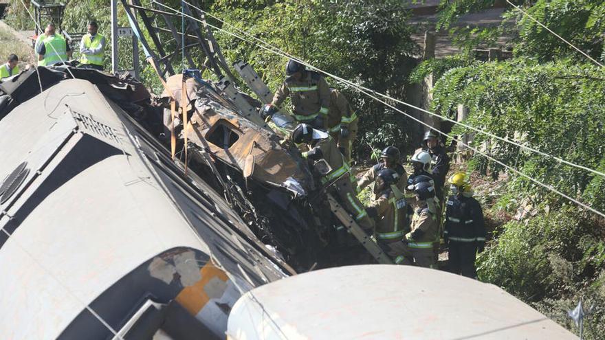 Los bomberos tratan de rescatar el cuerpo del maquinista de la cabina. // Marcos Canosa