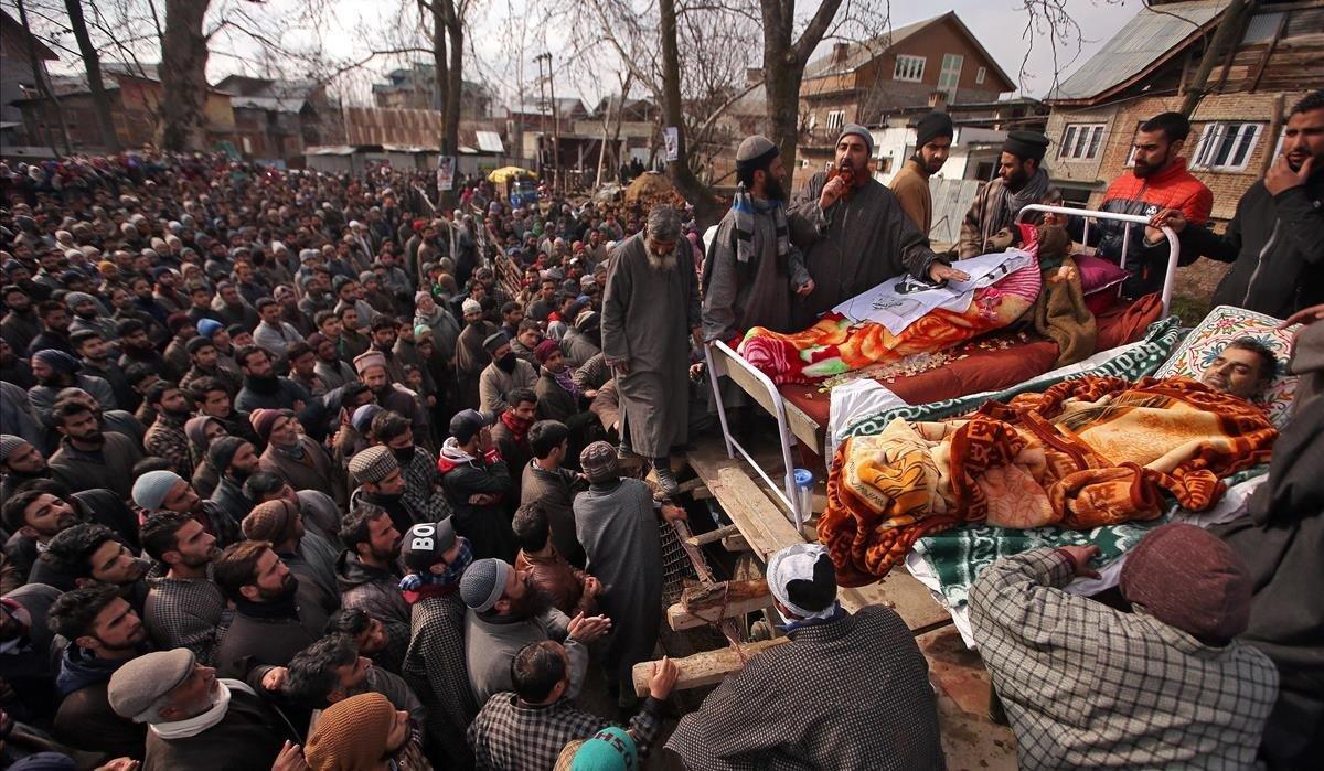 Gente reunida alrededor de los cuerpos de Mushtaq Ahmad, civil, y Hilal Ahmad Naikoo, presunto militante que, según los medios locales, fueron asesinados durante un enfrentamiento armado entre presuntos militantes y fuerzas de seguridad indias el lunes anterior. El funeral es en el pueblo de Pinglena en el sur del distrito de Pulwama en Cachemira.