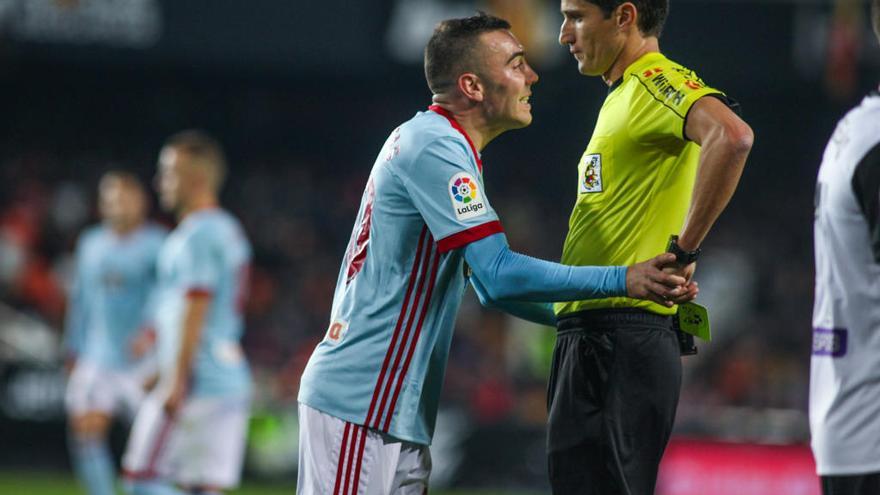 Aspas intenta evitar que Munuera Montero le muestre la amarilla, durante el partido disputado en Mestalla. // LOF