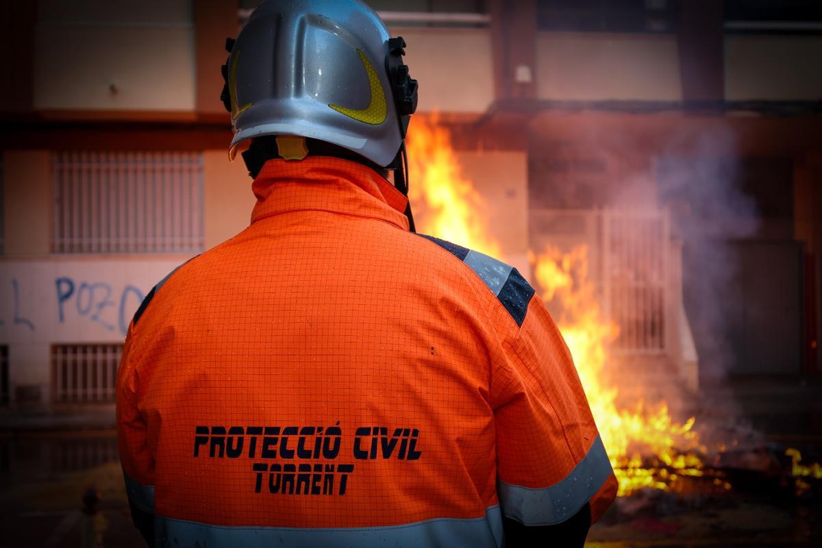 Un voluntario de Protección Civil vigila la cremà de una falla en Torrent