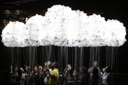A group of people pose for pictures with light installation "CLOUD" in Singapore