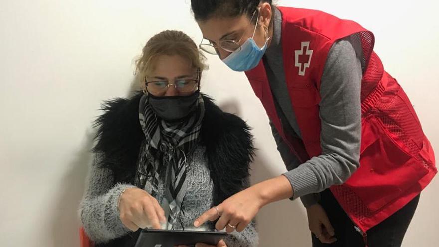 Una voluntària de Creu Roja mostrant com fer tràmits i gestions virtuals en un programa d&#039;alfabetització