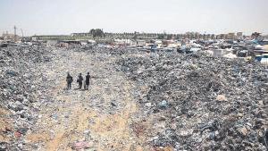 Unos niños palestinos caminan entre restos de basura junto al campo de refugiados de Yan Yunis. 