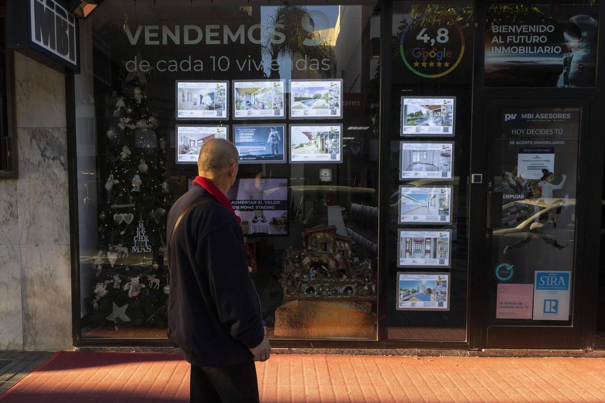 Un hombre observa la oferta de pisos en una inmobiliaria.
