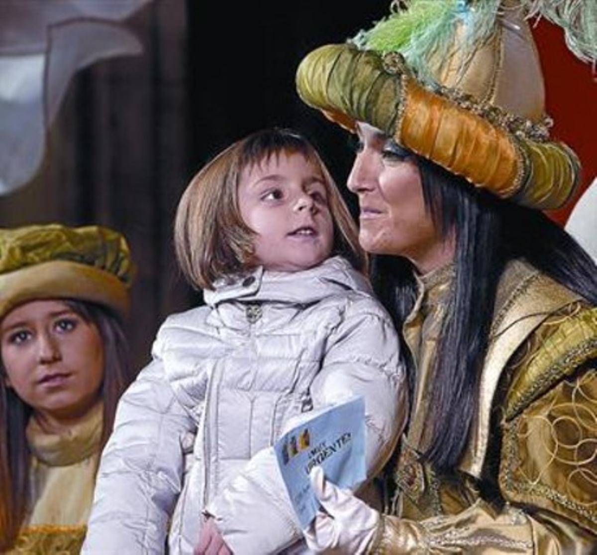 Una nena entrega la carta dels Reis a la patge Estel, ahir, a l’Ajuntament de Barcelona.