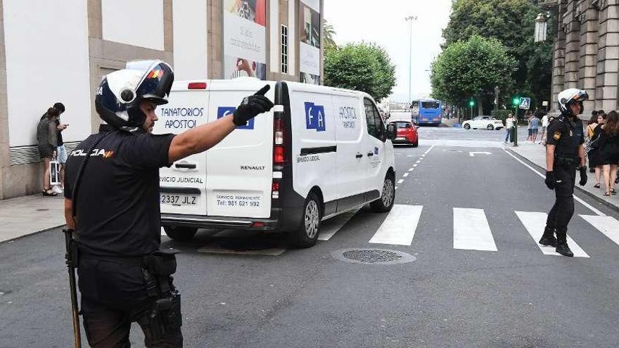 Agentes del 091 tras el furgón de la funeraria que se llevaba el cuerpo de la víctima del crimen de la Estrella.