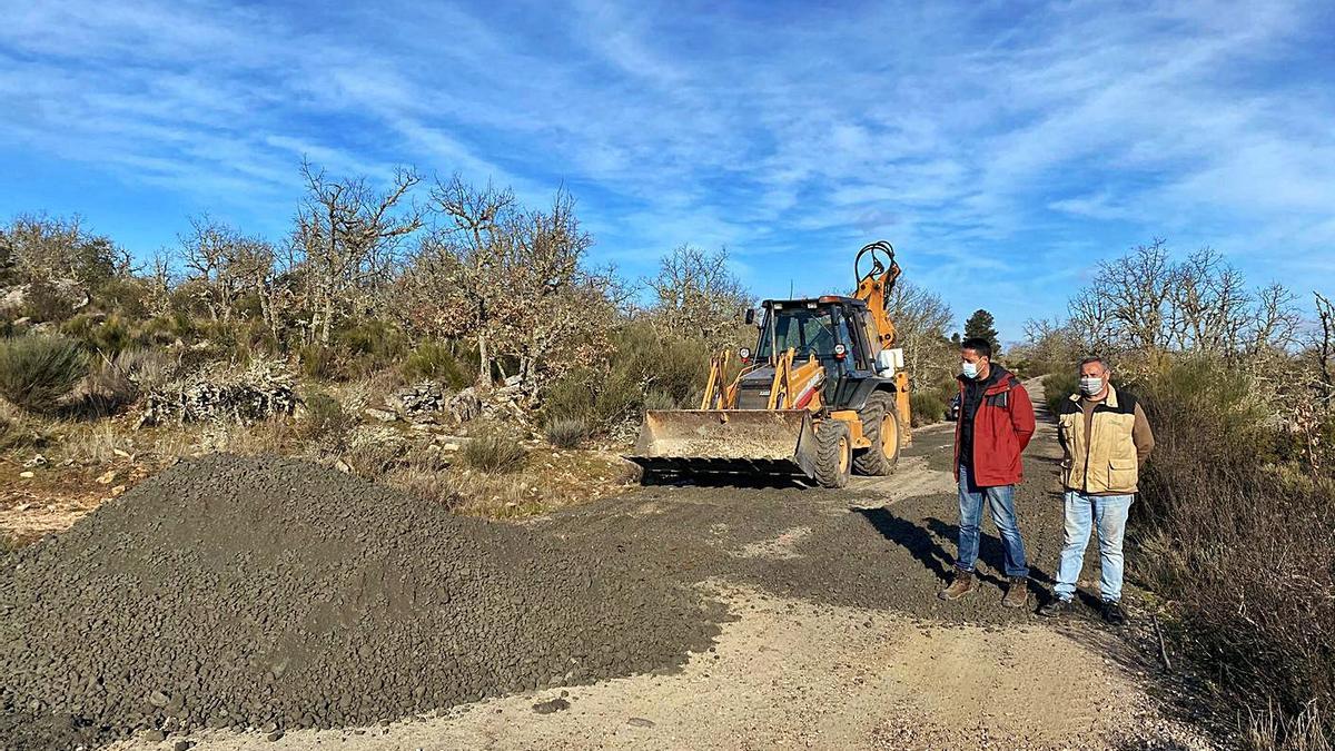 Sergio López y Baudilio Martínez observan las obras de bacheo en la vía que une Brandilanes y Moveros. | Ch. S.