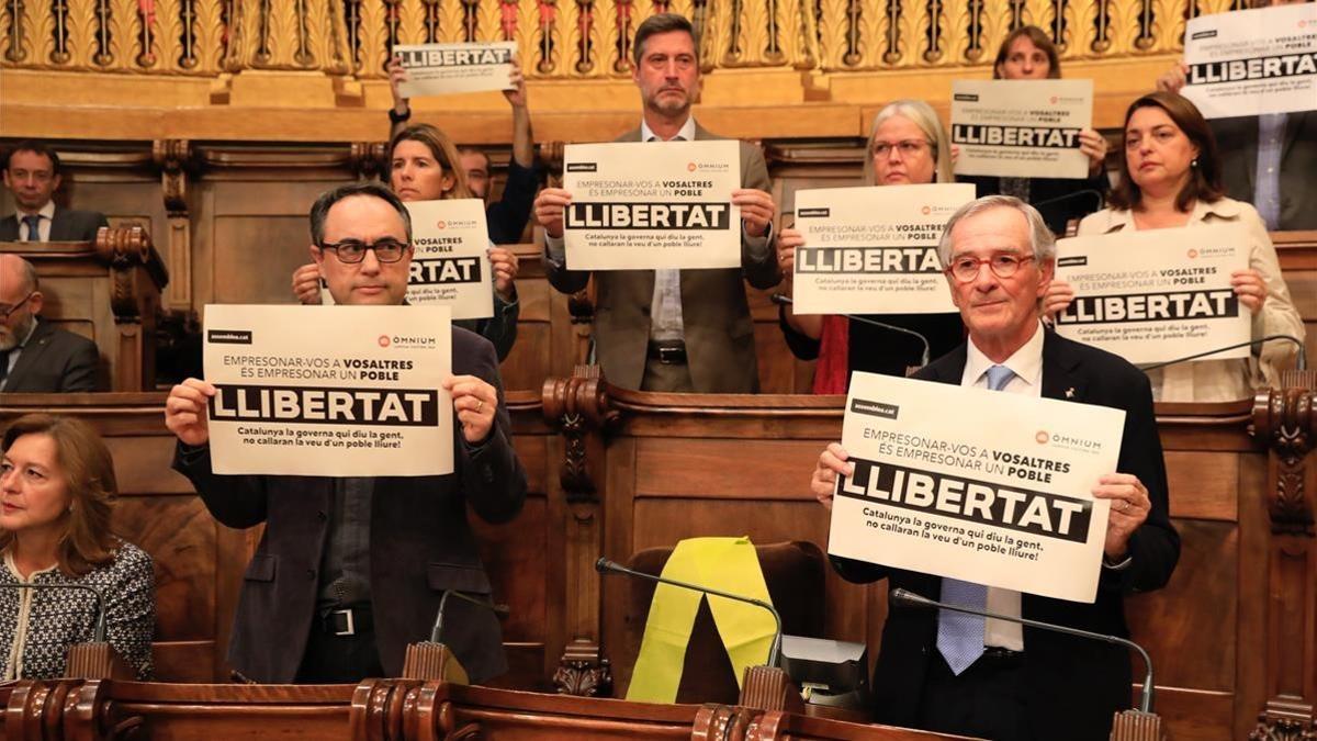 Los concejales del PDECat en Barcelona muestran carteles pidiendo la libertad de los encarcelados. Con un lazo amarillo, el lugar que ocupaba el exedil y 'exconseller' Joaquim Forn.
