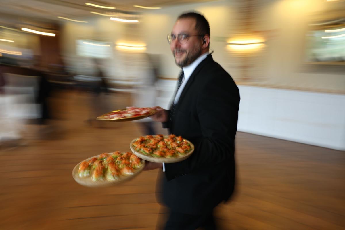 Un camarero lleva diversos platos.