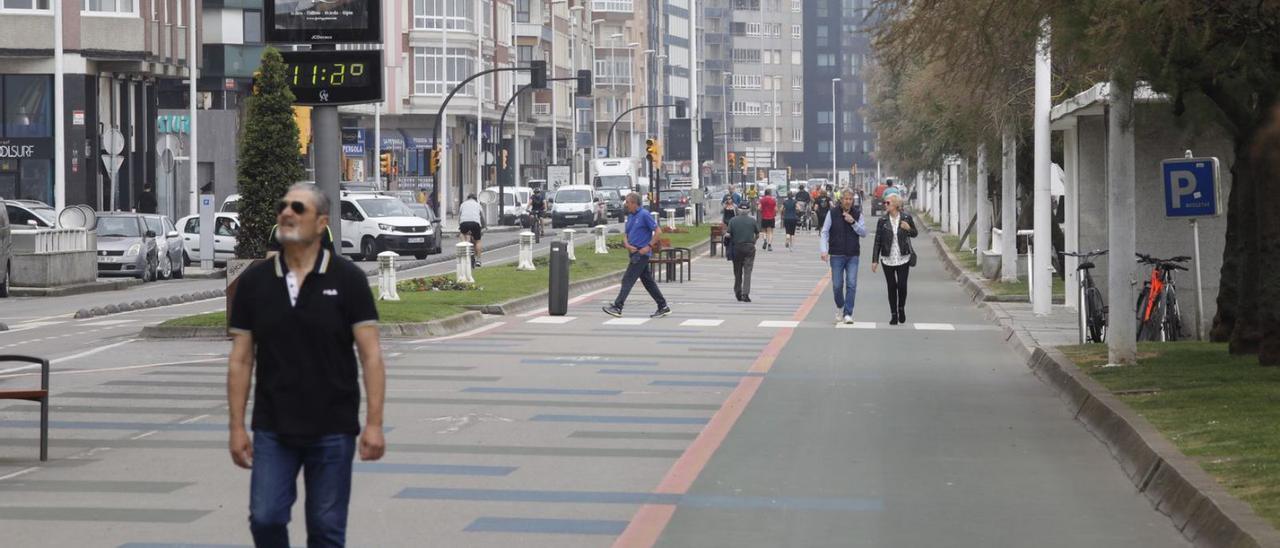 Paseantes por el “cascayu” del Muro, ayer. | Ángel González