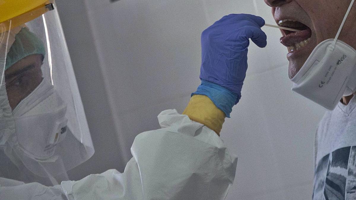 Un sanitario tomando una muestra para hacer una PCR en un centro de salud valenciano. | P. CORTES