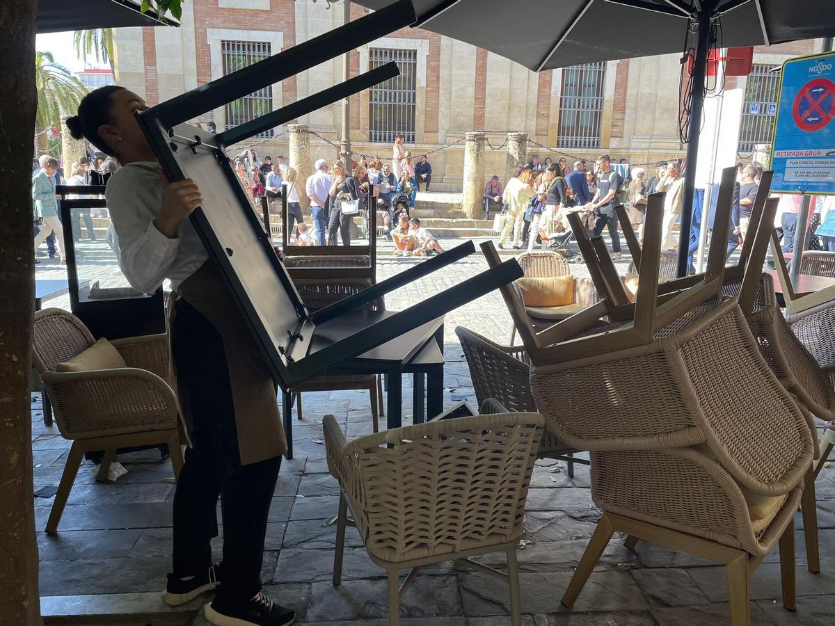 Una camarera retira los veladores durante esta Semana Santa en Sevilla.