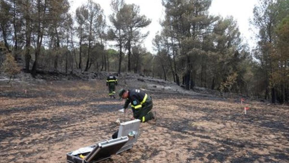 Dos agentes rurales trabajan en el punto donde empezó un incendio.