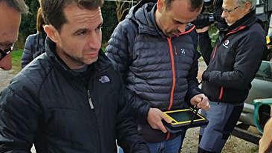Tècnics de la Generalitat mirant el mapa per buscar les fites de la línia