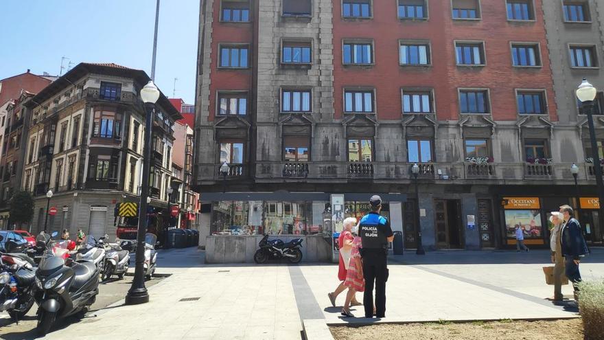 La Policía, en la plaza del Parchís de Gijón; al fondo, el edificio en cuya azotea esta el perro.