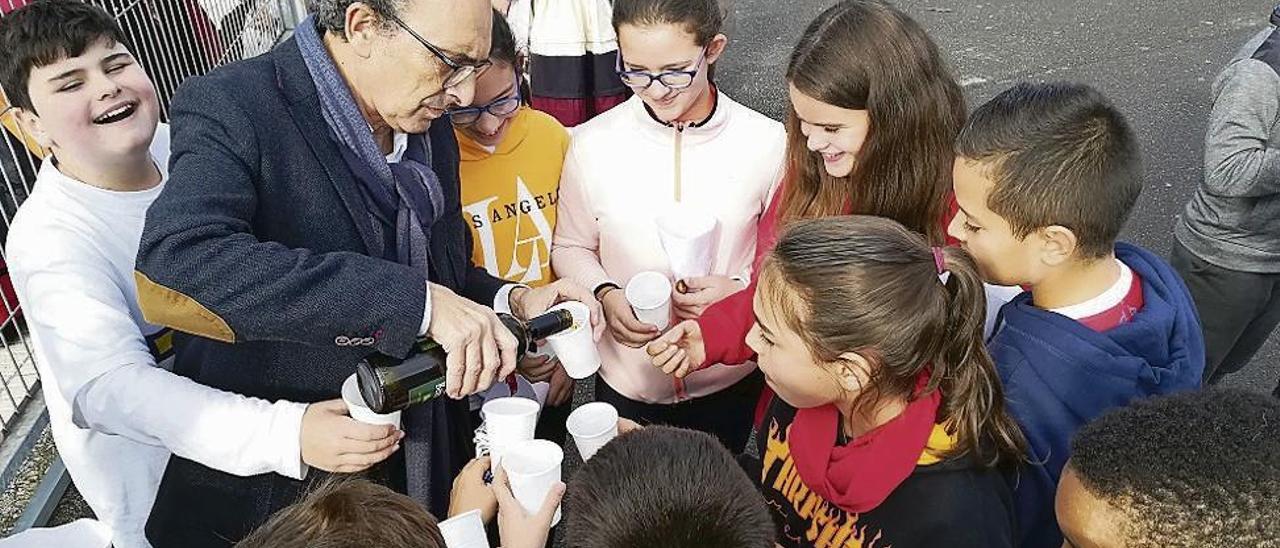 Miguel Güemes sirve sidra dulce a un grupo de alumnos.