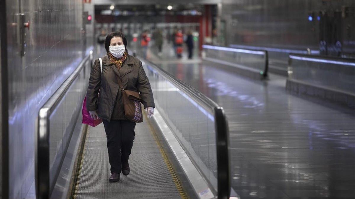 Una mujer con mascarilla para protegerse del coronavirus en la estación de metro de Diagonal, en Barcelona