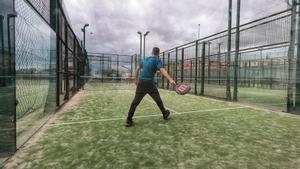 Dos jóvenes se ejercitan en una cancha de tenis.