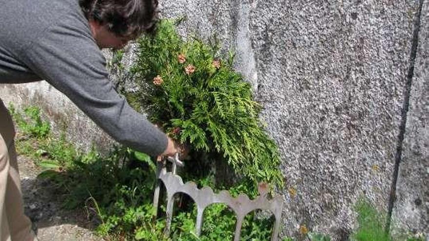 Manuel Pérez Lorenzo muestra el relieve, oculto tras las flores