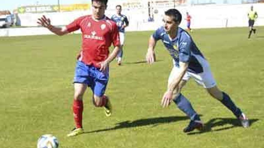 Un jugador del Benavente y otro del Moraleja luchan por el balón.