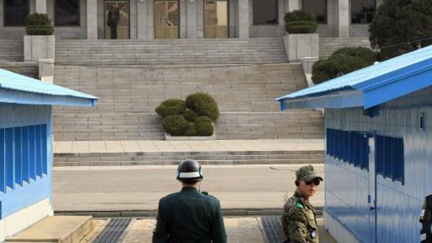 Soldados surcoreanos, ayer, en guardia ante la línea de división. Al fondo, un militar de Corea del Norte.