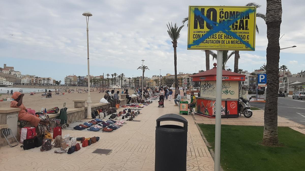 Imagen de archivo de venta ambulante en el paseo de Peñíscola, junto a un cartel que la prohibe.