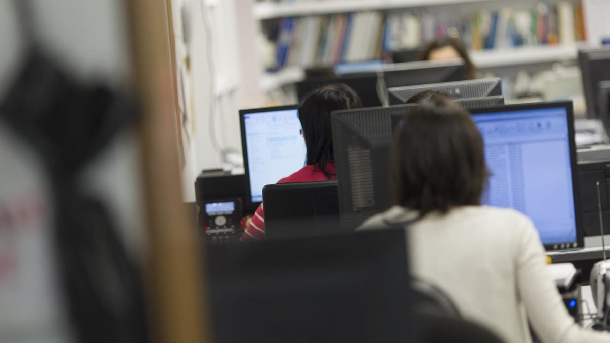 Alumnos con ordenadores en un aula.