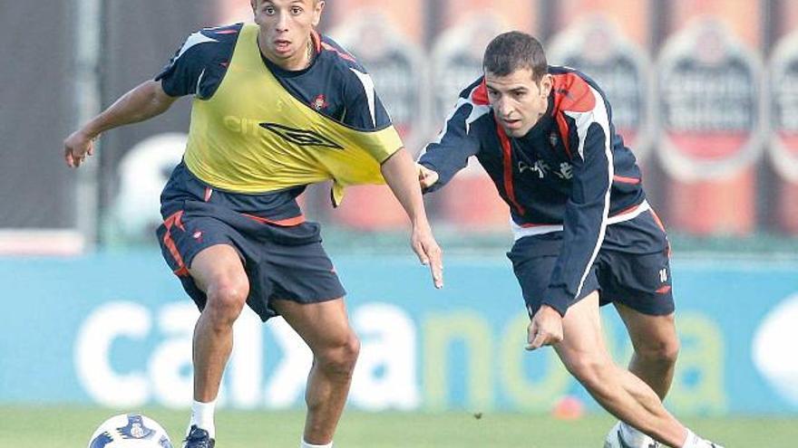 Ghilas conduce el balón perseguido por Trashorras, en un entrenamiento en A Madroa.