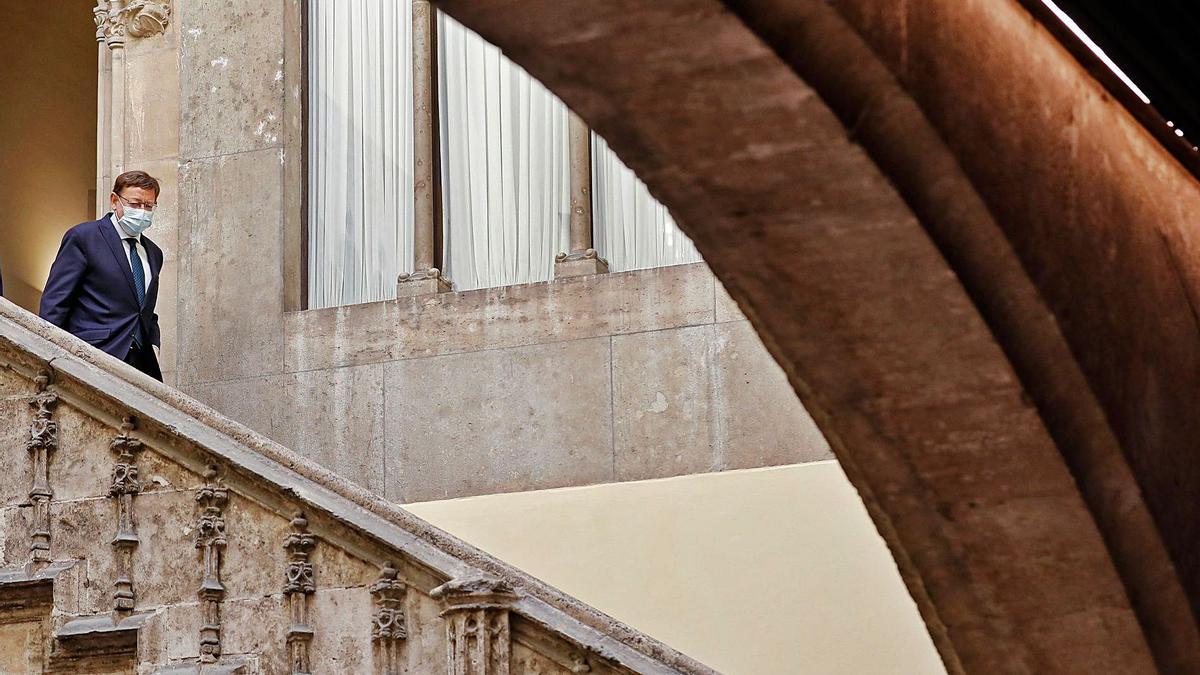 El presidente de la Generalitat Valenciana, Ximo Puig, baja por la escalera del patio gótico del Palau de la Generalitat.