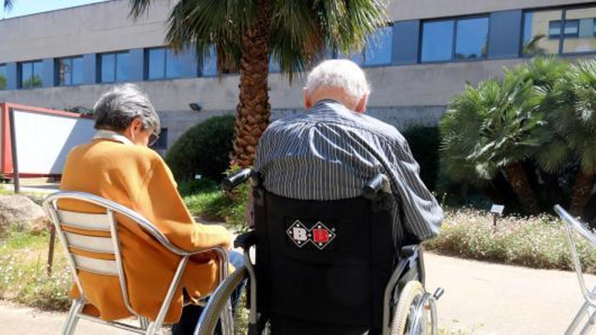 Dues persones d'edat avançada prenen el sol a la residència Palamós Gent gran.