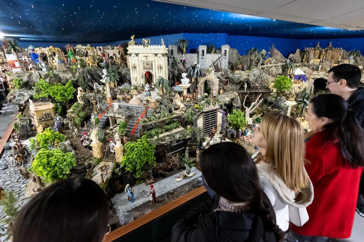 Varias personas observan el belén de la Diputación
