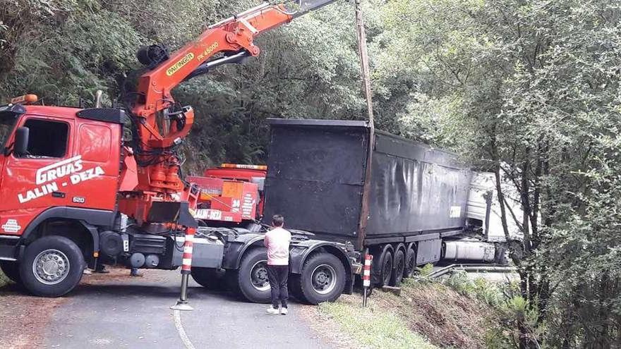 Fueron necesarias dos grúas para poder desatascar el camión, que corría peligro de caer al río.