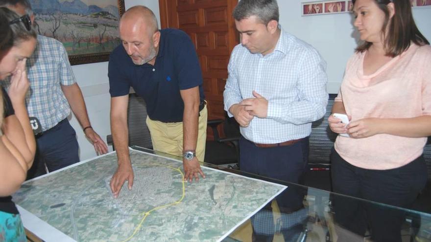 El alcalde observa, junto al presidente del Consell y la consellera de Territorio, los cambios introducidos sobre una fotografía aérea.