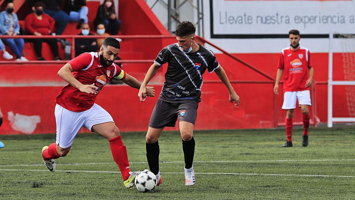 El capitán de Las Zocas, Aday, disputa el balón al jugador del Candela Erik, en el choque del Juanito Marrero.