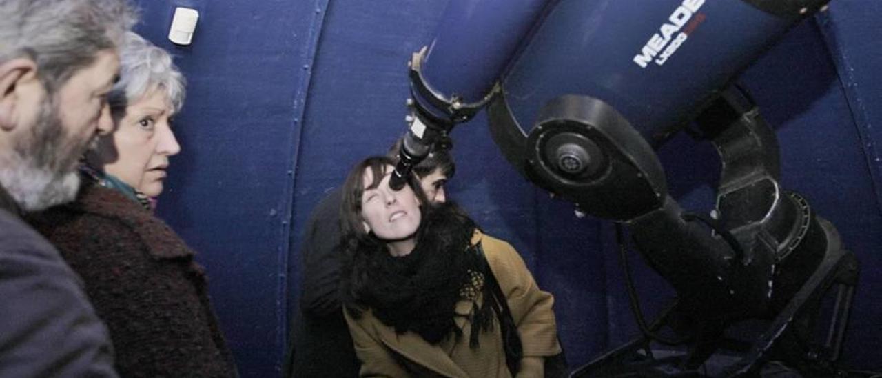 Una mujer observa por un telescopio en el observatorio de Costitx.