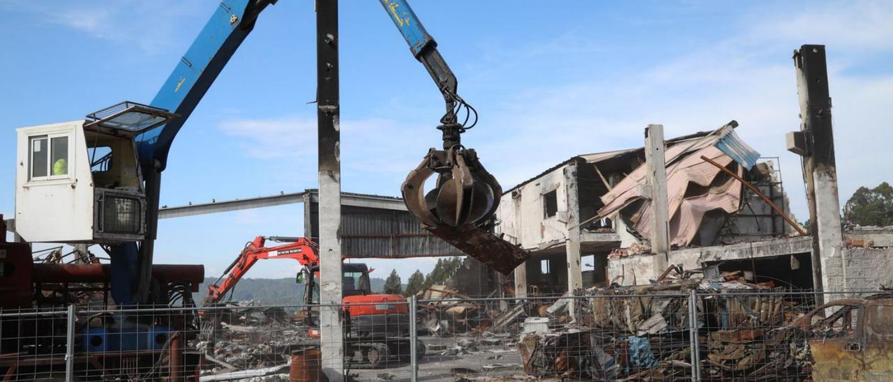 Trabajos de demolición de las naves calcinadas en el Rebullón, ayer.  |  // ANXO GUTIÉRREZ