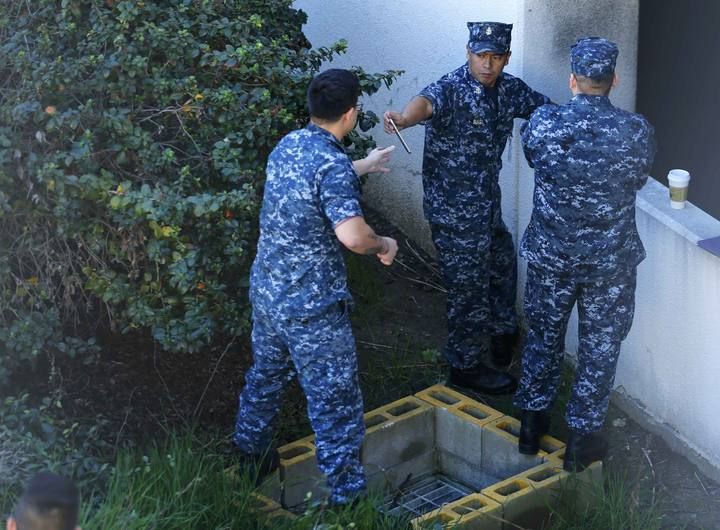 Navy personnel converge near parking garage adjacent to Building 26 at the Naval Medical Center in San Diego