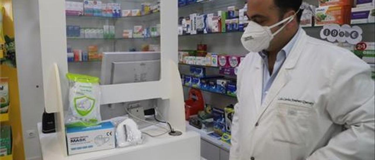 Un farmacéutico observa mascarillas puestas a la venta en un establecimiento, en una imagen de archivo.