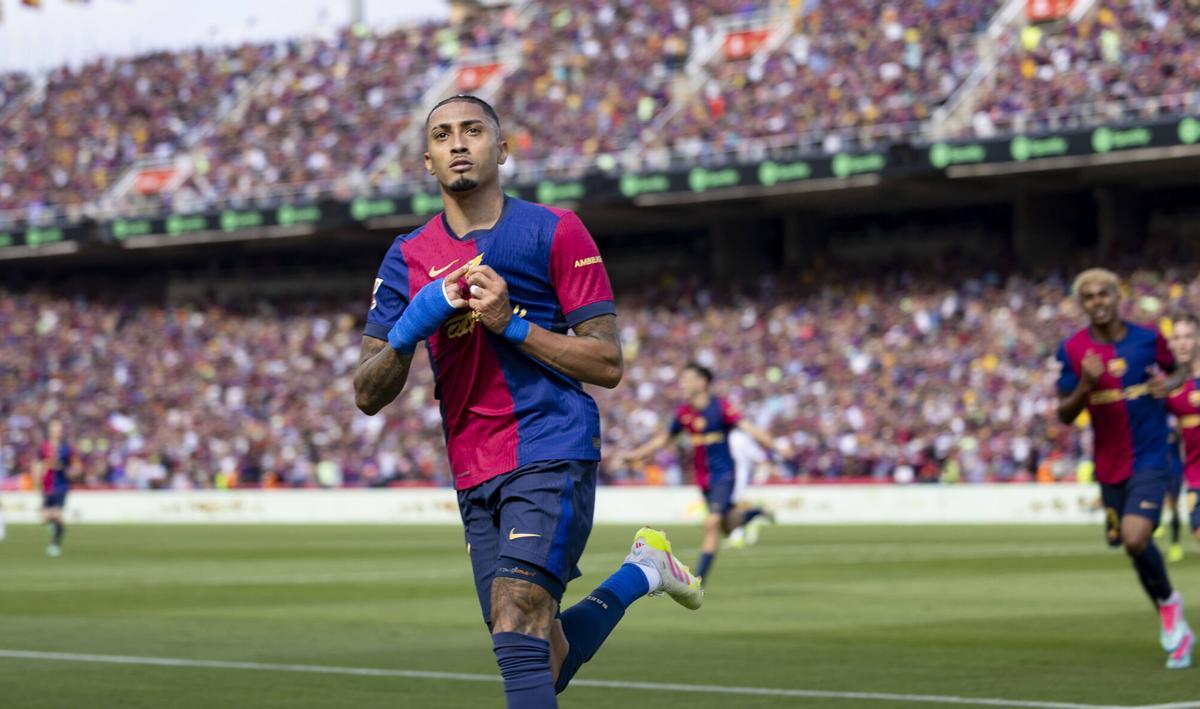 Raphinha enseña orgulloso el escudo tras marcar su segundo gol, el 4-2.