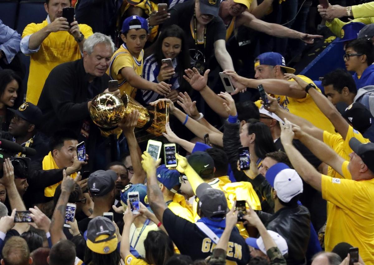 MMD17 OAKLAND (ESTADOS UNIDOS) 13/06/2017.- Stephen Curry (c), de los Warriors de Golden State, alza el trofeo de campeones tras vencer a los Cavaliers de Cleveland en el quinto partido de las Finales de la NBA en el pabellón Oracle Arena de Oakland, California (Estados Unidos) el 12 de junio de 2017. EFE/Monica M. Davey